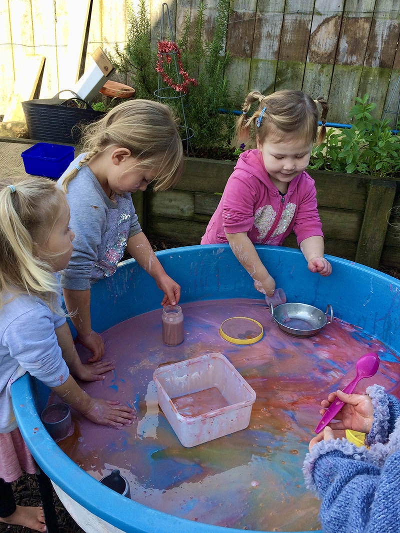 Kindergarteners playing with coloured water